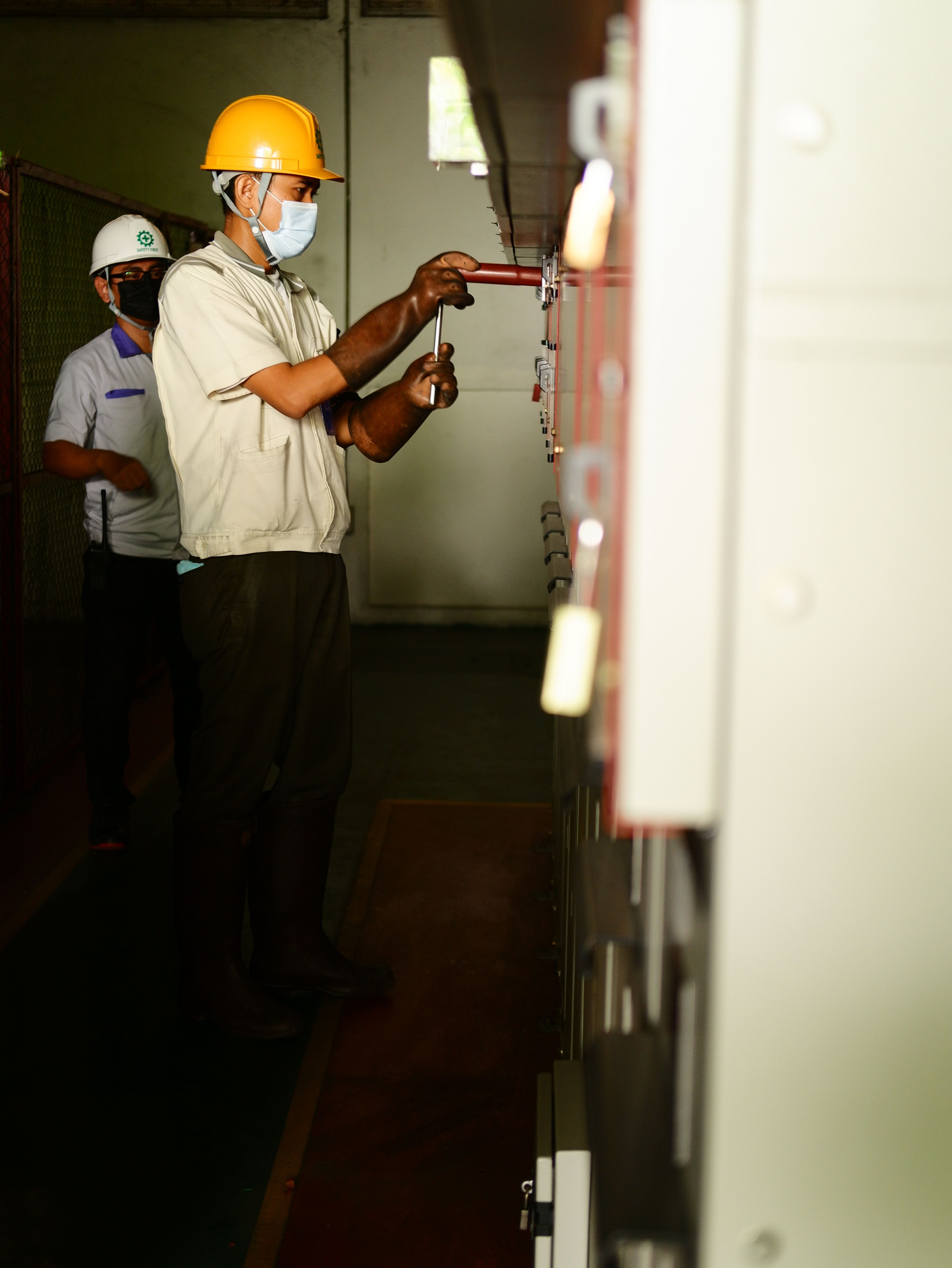 Electrical technicians working at industrial control equipment